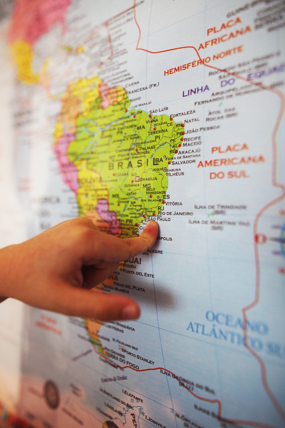 A child points to Sao Paulo on a paper map.
